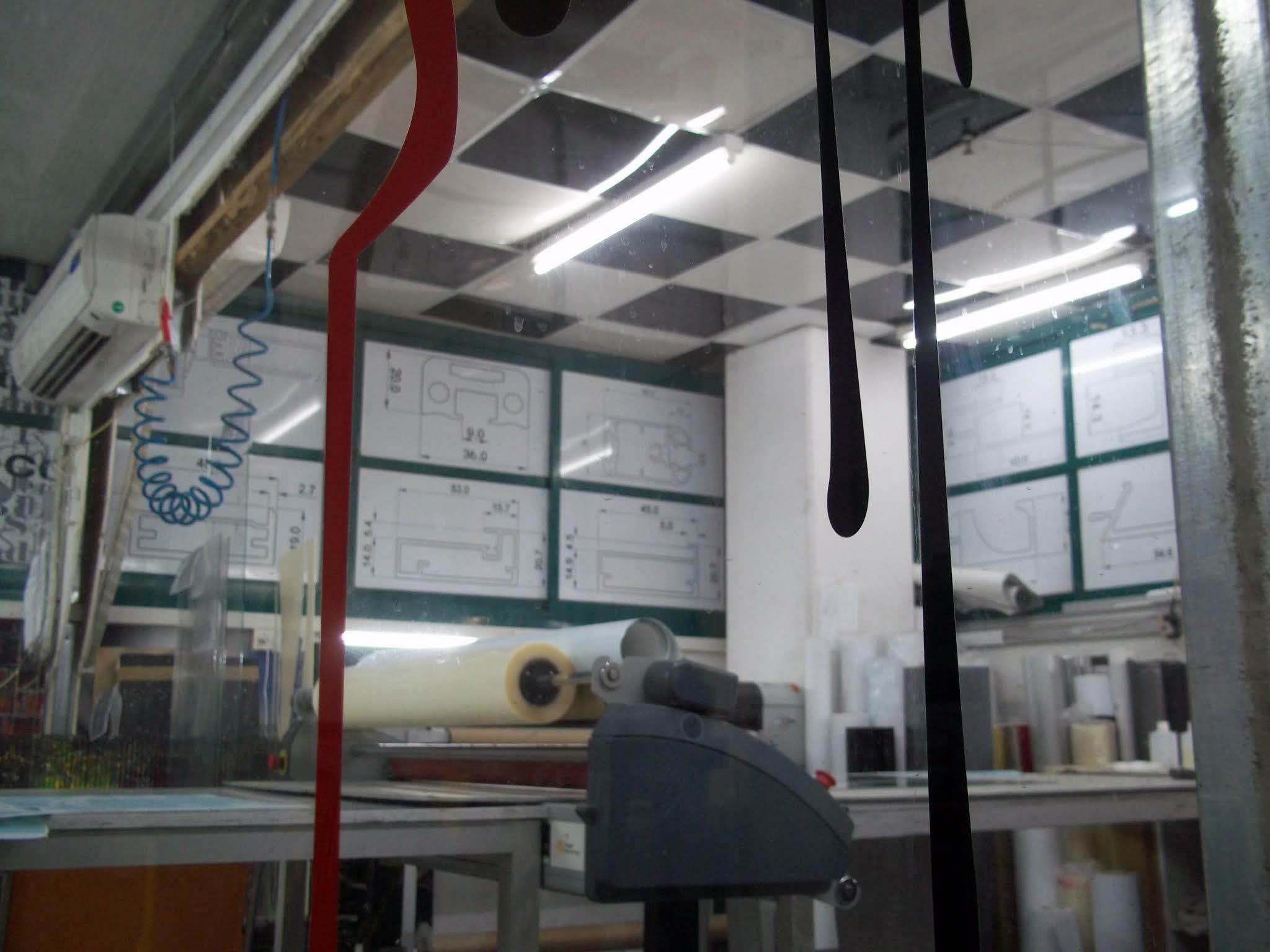 Glass partitions, equipment, and overhead lights inside the workshop.